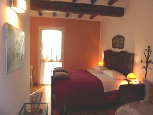 een slaapkamer met een bed met rode lakens en een raam bij La Casa di Campagna in Reggio Emilia