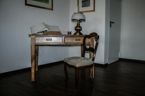 a desk with a lamp and a chair in a room at Hotel Quadrifoglio in Caraglio