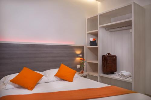 a bedroom with a bed with orange pillows and a television at Viverenumana in Numana