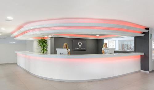 two women sitting at a counter in a building at Hotel Vibra Mare Nostrum in Playa d'en Bossa