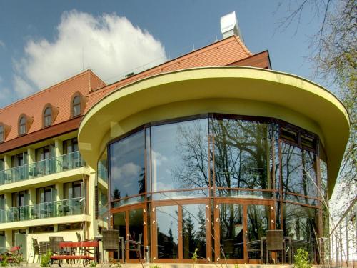a building with a large glass window in front of it at Wellness Hotel Gyula in Gyula