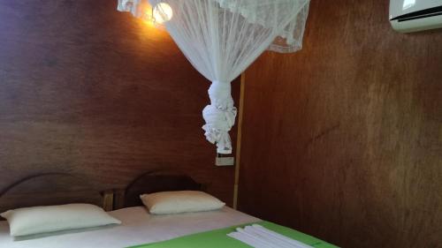 a bedroom with a bed with a curtain and pillows at Sigiri Forest View in Sigiriya