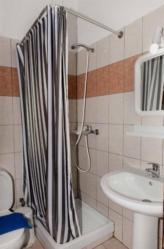 a bathroom with a shower curtain and a sink at Saonisos in Kamariotissa
