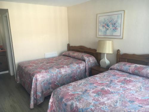 una habitación de hotel con 2 camas y una lámpara en Surf Haven Motel, en North Wildwood