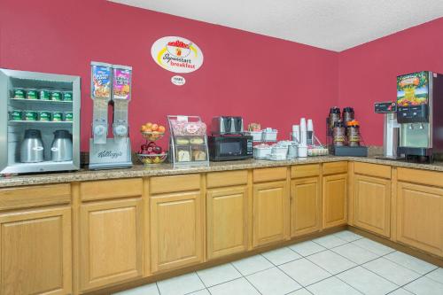a coffee shop with a red wall at Super 8 by Wyndham Roanoke VA in Roanoke