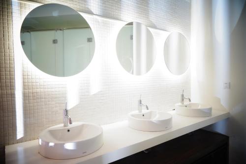 a bathroom with two sinks and two mirrors at Borough Capsule Hostel Bali in Legian