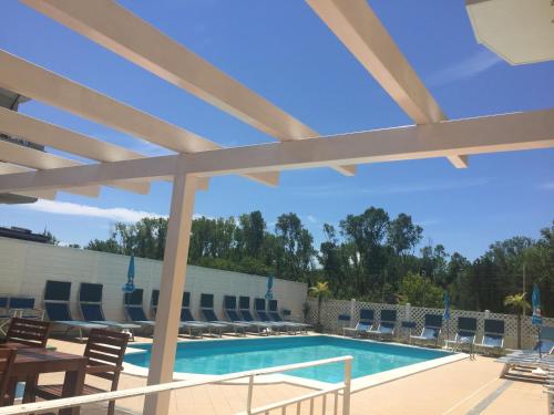 a swimming pool with chairs and a table at Hotel Viking in Rimini