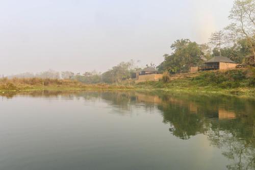 a river with houses on the side of it at Jagatpur Lodge by Annapurna in Khargauli