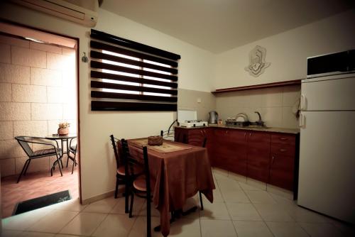 a kitchen with a table and a kitchen with a refrigerator at Mali Country Hospitality in Eilat