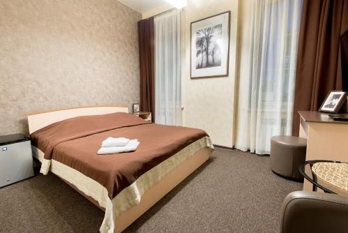 Una habitación de hotel con una cama con dos toallas. en Shale on Komsomolsky, en Novosibirsk