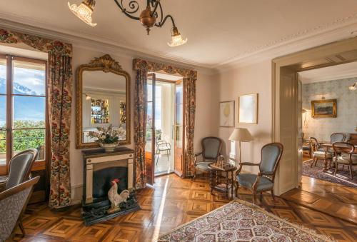 a living room with a fireplace and a mirror at Swiss Historic Hotel Masson in Montreux
