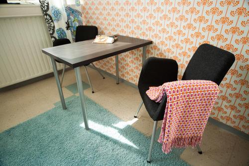 a table and chairs in a room with a table and a chair at Yömyssy Apartments in Kerimäki