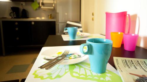 a table with a plate and two cups on a table at Yömyssy Apartments in Kerimäki
