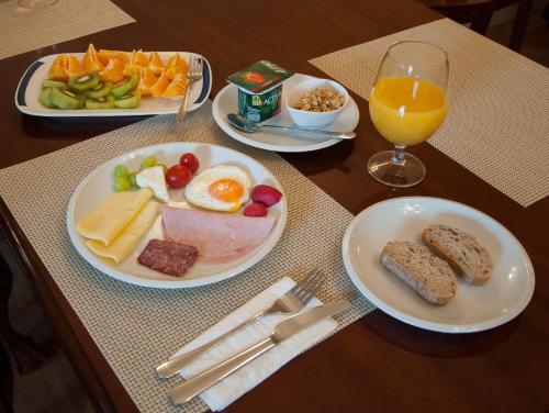 a table with plates of breakfast food and a glass of orange juice at Zámek Jeseník Nad Odrou in Jeseník nad Odrou