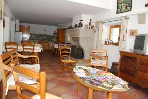 a living room with a table and chairs and a tv at Chambre d'hôtes Kieffer Le Grand Bienfaisy in Remiremont
