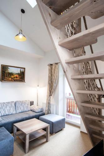 a living room with a blue couch and stairs at Apartment Jelena1 in Tatranská Lomnica