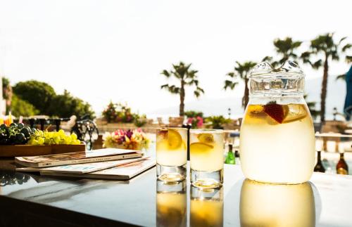 two glasses of lemonade on a table with palm trees at Torbahan Hotel in Torba