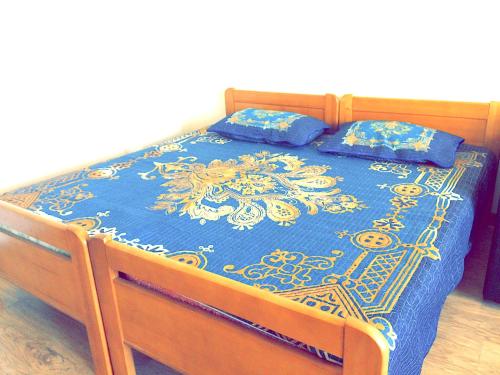 uma cama com um edredão azul e duas almofadas em Khan Shatyr Apartment em Astana