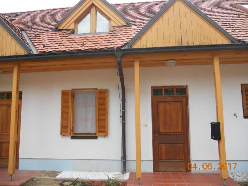 Casa blanca con puerta y ventanas de madera en Nagelj 1 en Martjanci