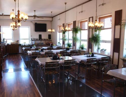 a dining room with tables and chairs and chandeliers at Hotel Suonenjoki in Suonenjoki