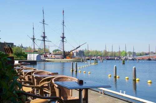 a table and chairs in a marina with a ship at Pension Homeland in Amsterdam