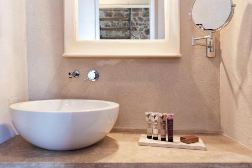 a bathroom with a white sink and a mirror at Casanova di Neri Relais in Montalcino