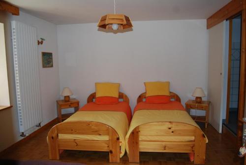 a bedroom with two twin beds and two tables at Chambre d'hôtes Kieffer Le Grand Bienfaisy in Remiremont
