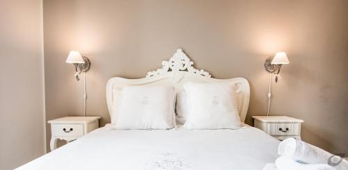 a white bed with white pillows and two lamps at B&B La Sosta degli Artisti in Pietrasanta