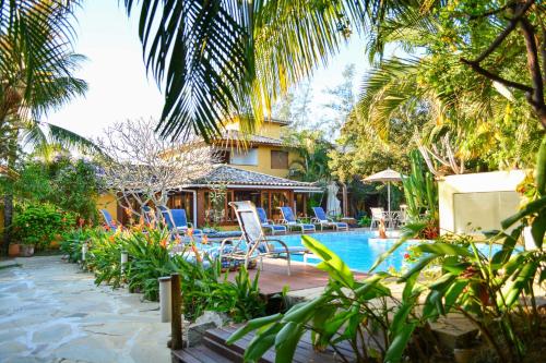 a resort with a swimming pool and palm trees at Pousada do Namorado in Búzios