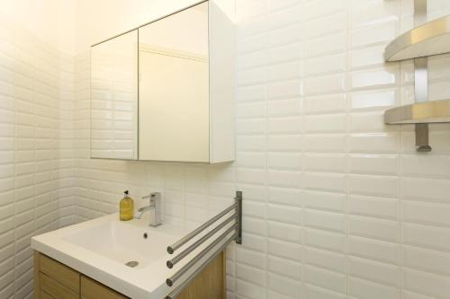 une salle de bain blanche avec un lavabo et un miroir dans l'établissement Apartment Balme 3B - A Chamonix Mont Blanc Haven, à Chamonix-Mont-Blanc
