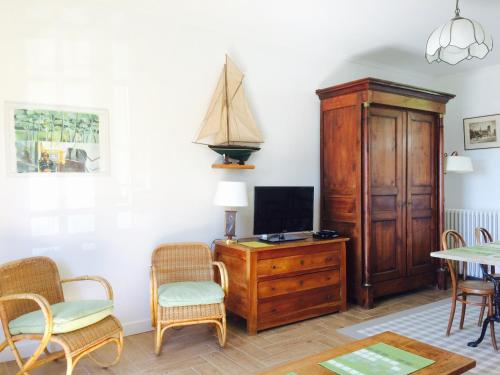 un salon avec une télévision, une table et des chaises dans l'établissement Villa Thérèse, à Mers-les-Bains