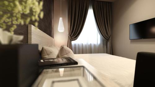 a hotel room with a bed and a window at The Square Hotel in Skudai
