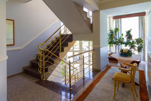 a hallway with stairs and a table and a chair at Hotel Sunce Sarajevo Vogosca in Vogošća