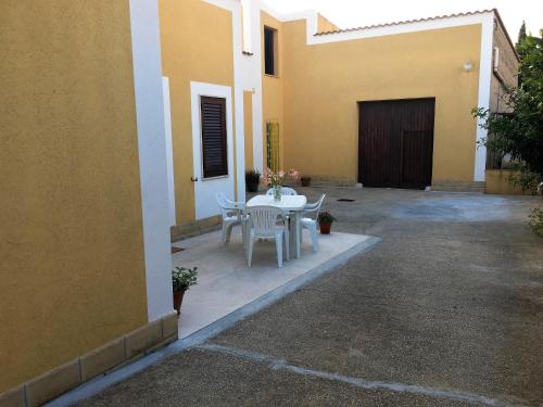 a patio with a table and chairs next to a building at Il Giardino dei Limoni in Custonaci
