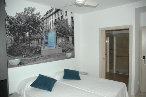 um quarto com uma cama com uma fotografia na parede em Pensión Koxka em San Sebastián