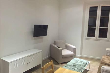 un salon avec une chaise et une télévision dans l'établissement 202-Appartement renove vieil antibes, à Antibes