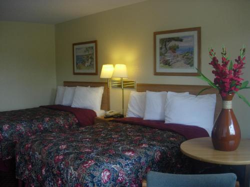 A bed or beds in a room at Western Inn & Suites