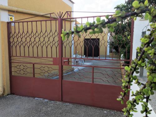 a red gate with a courtyard behind it at Il Giardino dei Limoni in Custonaci