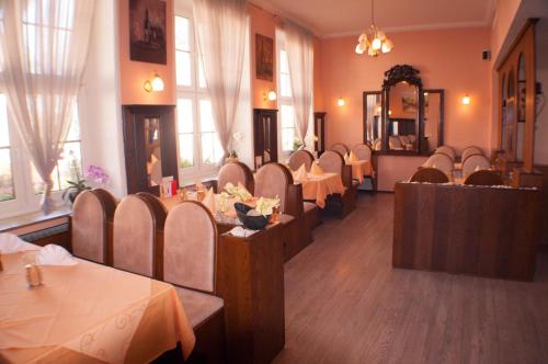 ein Restaurant mit Tischen, Stühlen und einem Spiegel in der Unterkunft Hotel Stadt Emmerich in Emmerich