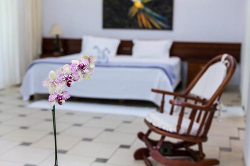 a bedroom with a bed and a flower and a chair at Hotel Parque Das Primaveras in Caldas Novas
