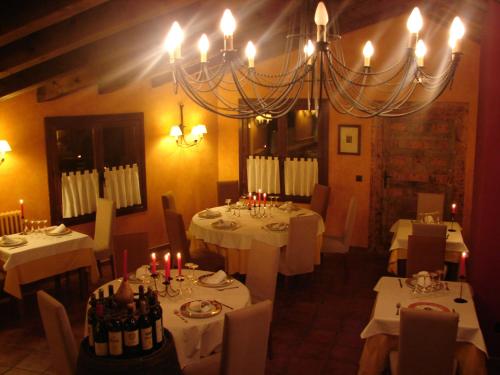 a dining room with white tables with candles and bottles of wine at Posada Los Templarios in Ucero