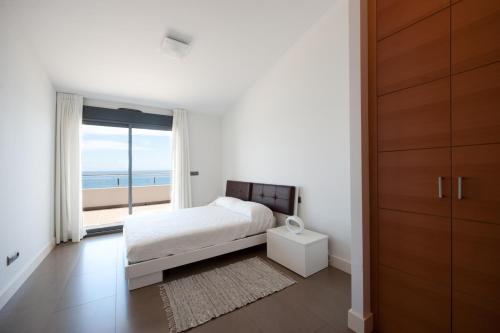 a bedroom with a bed and a view of the ocean at Apartamentos Calpestabili in Altea