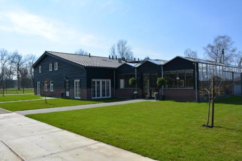 a black house with a green lawn in front of it at 2 persoons appartement in Heeze
