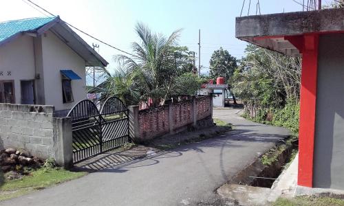 an empty street with a fence and a house at pulau weh sabang marifi in Paya