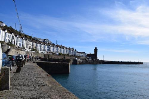 a row of houses next to a body of water at Harbour Inn in Porthleven