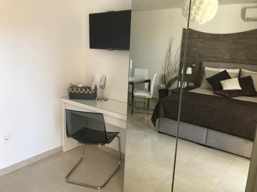 a bedroom with a bed and a desk with a television at Apartments Maritea in Vodice
