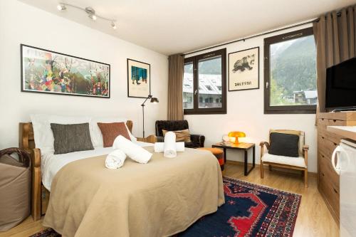 a bedroom with a bed and a tv and windows at Apartment Gentianes in Chamonix