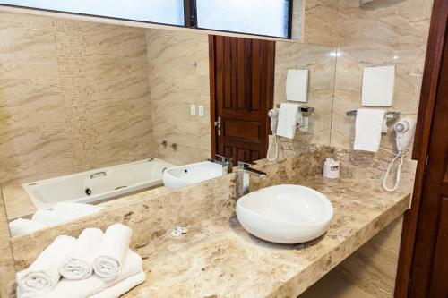 a bathroom with a sink and a tub at Hotel Parque Das Primaveras in Caldas Novas