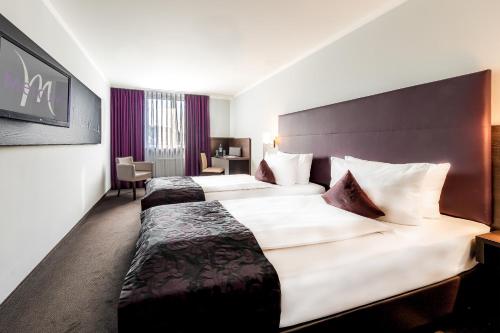 a hotel room with two large beds in it at Mercure Frankfurt City Messe in Frankfurt