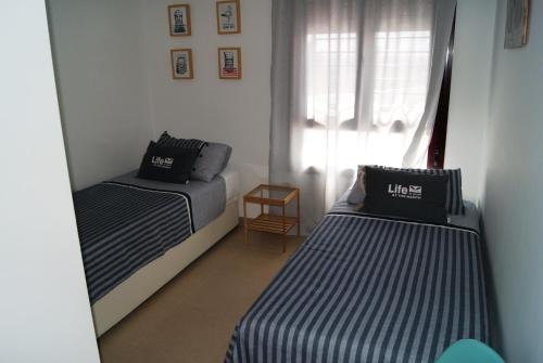 mały pokój z 2 łóżkami i oknem w obiekcie Apartamento Tirma Conil w mieście Conil de la Frontera